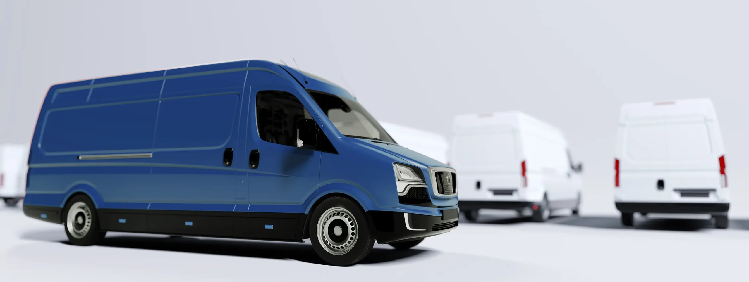 Blauer Transporter mit schwarzem Unterboden und silbernen Radkappen, im Hintergrund mehrere weiße Transporter unscharf.